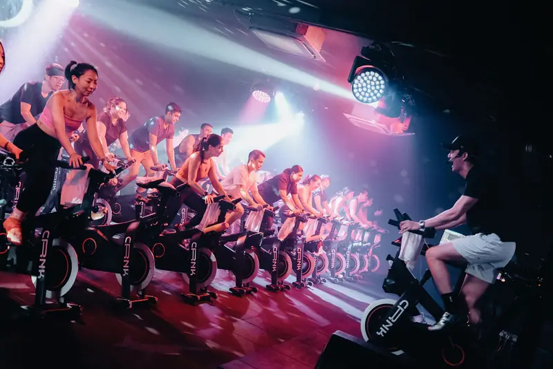 A packed CRNK ride in red and pink light, instructor up front