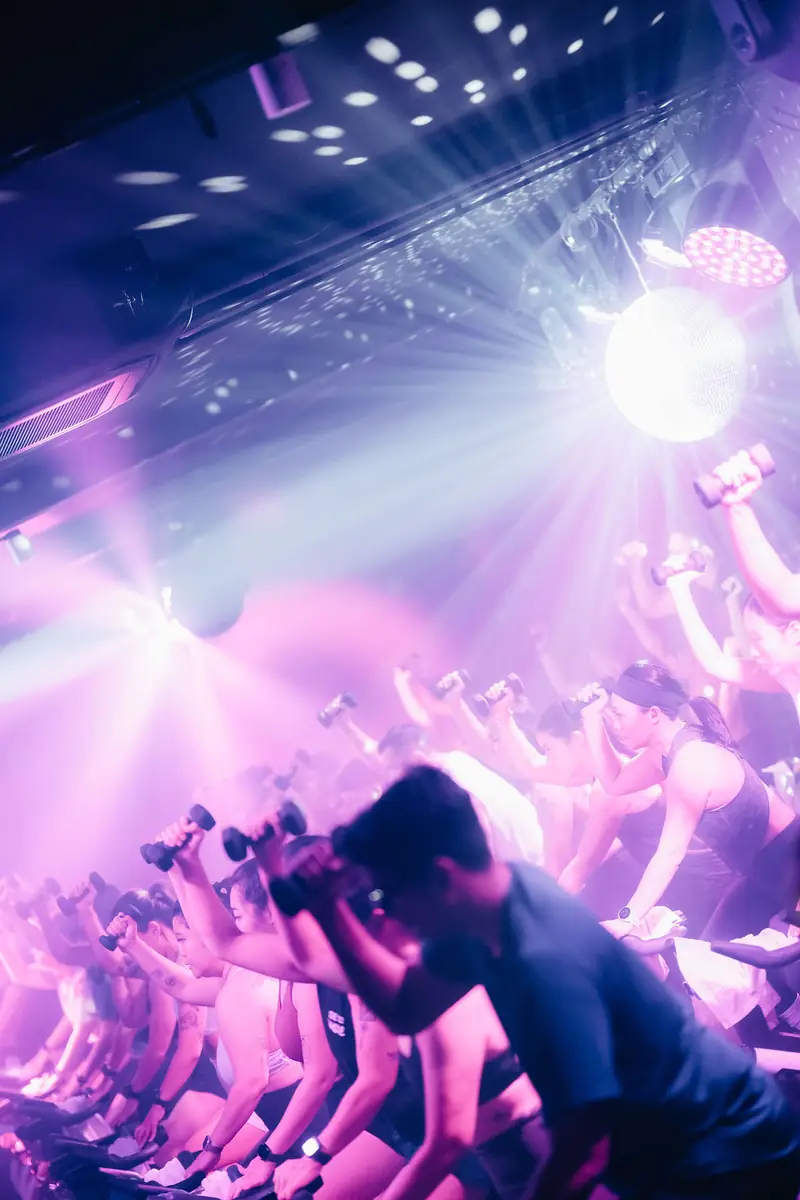 A disco-ball light burst in purple over riders