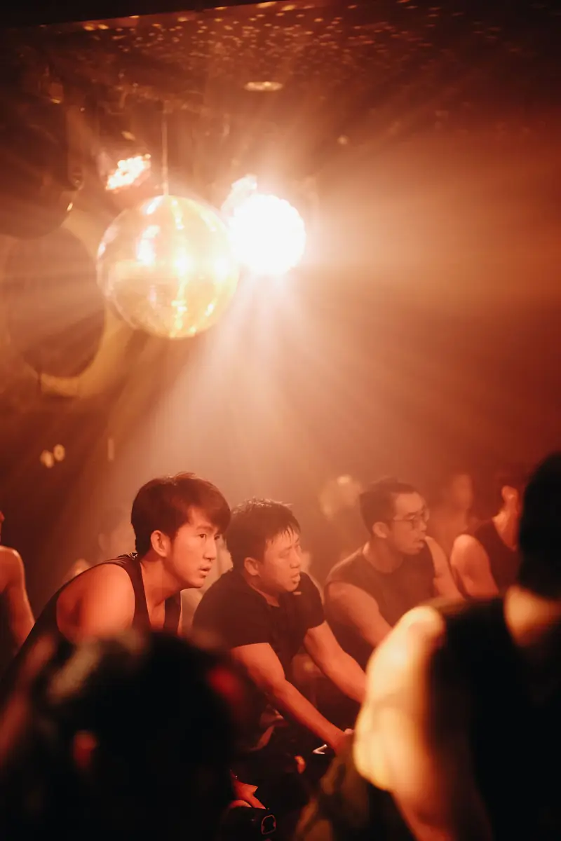 A disco ball and warm light over riders mid-class